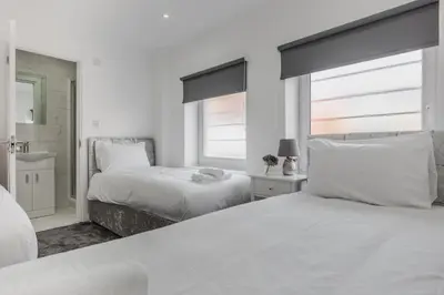 a white bedroom with two beds and a window at RST Luxury Aparthotel in Liverpool