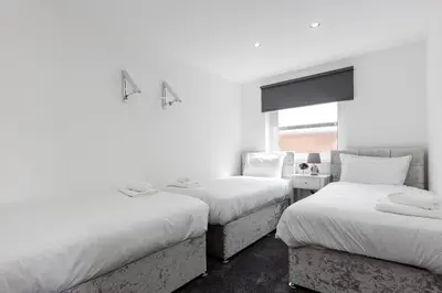 two beds in a room with white walls at RST Luxury Aparthotel in Liverpool