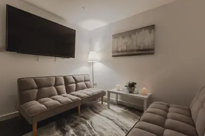 a living room with a couch and a flat screen tv at RST Luxury Aparthotel in Liverpool