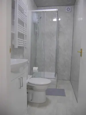 a bathroom with a shower and a toilet and a sink at Mermaid Holiday Flats in Blackpool