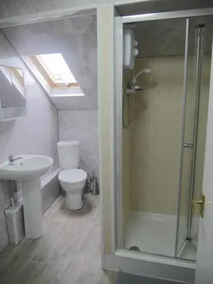 a bathroom with a shower and a toilet and a sink at Mermaid Holiday Flats in Blackpool