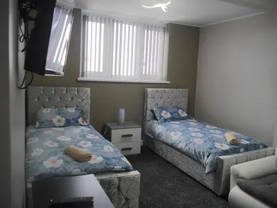 a bedroom with two beds and a couch at Mermaid Holiday Flats in Blackpool