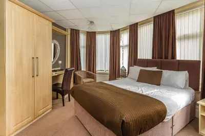 a bedroom with a bed and a desk in a room at Cherry Tree House in Blackpool
