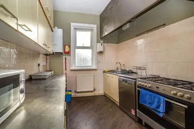 a kitchen with a sink and a stove top oven at Cherry Tree House in Blackpool