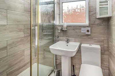 a bathroom with a toilet and a sink and a shower at Cherry Tree House in Blackpool