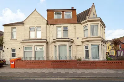 a large house with a fence in front of it at Cherry Tree House in Blackpool