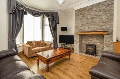 a living room with a couch and a fireplace at Cherry Tree House in Blackpool