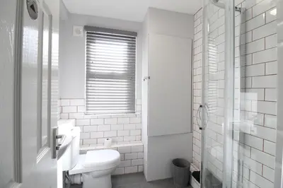 a white bathroom with a toilet and a window at Anfield house in Liverpool