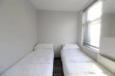two beds in a small room with a window at Anfield house in Liverpool