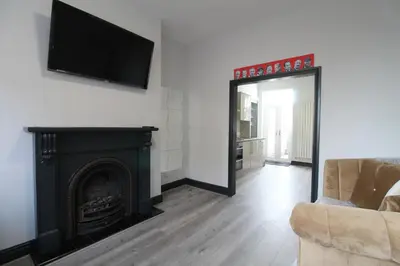 a living room with a fireplace and a flat screen tv at Anfield house in Liverpool