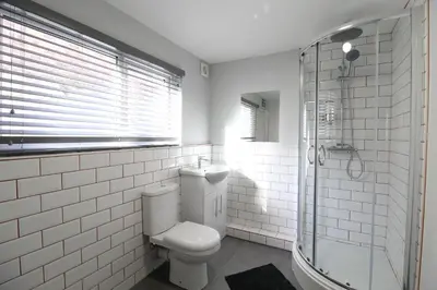 a white bathroom with a toilet and a shower at Anfield house in Liverpool