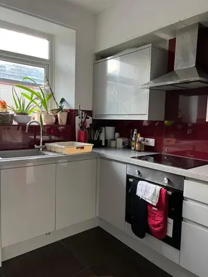 a kitchen with white cabinets and a sink at Arnside sea view in Arnside