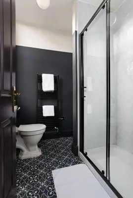 a bathroom with a toilet and a glass shower at Swan & Railway Hotel Wigan in Wigan