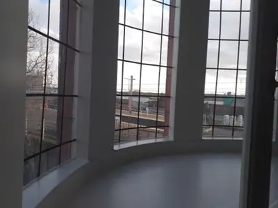a room with two windows with a view of a building at Swan & Railway Hotel Wigan in Wigan