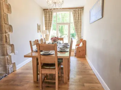 a dining room with a wooden table and chairs at Clock Tower in Grange Over Sands