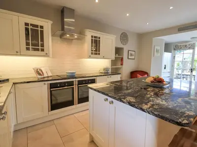 a kitchen with white cabinets and a granite counter top at Clock Tower in Grange Over Sands