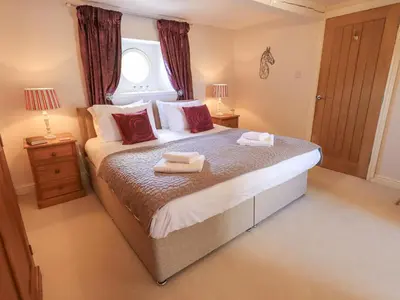 a bedroom with a large bed with two towels on it at Clock Tower in Grange Over Sands