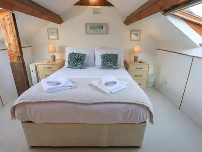 a bedroom with a large bed with towels on it at Clock Tower in Grange Over Sands