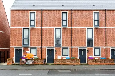 a person riding a scooter in front of a brick building at Newbuild 4bed - City Centre - Free secure parking! By Hinkley Homes Short Lets & Serviced Accommodation in Liverpool