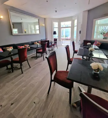 a restaurant with tables and chairs and a mirror at The Bosworth House Hotel in Blackpool