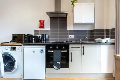 a kitchen with a washer and dryer in it at Cosy Studio in Merseyside in Great Location in Liverpool