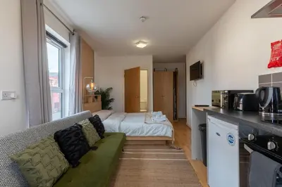 a living room with a couch and a kitchen at Cosy Studio in Merseyside in Great Location in Liverpool
