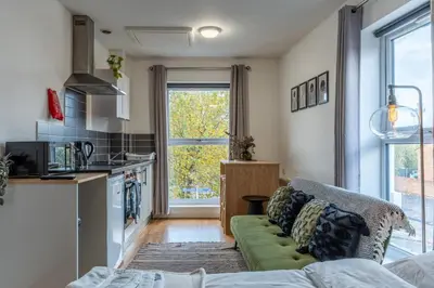 a living room with a couch and a kitchen at Cosy Studio in Merseyside in Great Location in Liverpool