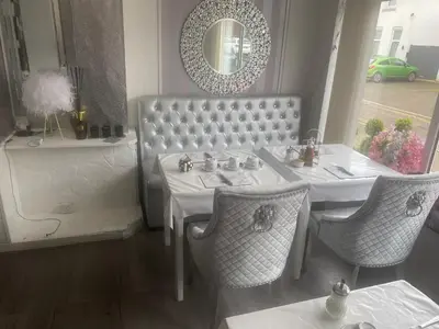 a dining room with a table and chairs and a mirror at The Cosy Nook in Blackpool