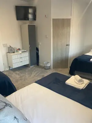 a hotel room with two beds and a television at The Cosy Nook in Blackpool