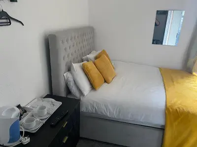 a bedroom with a bed with yellow pillows and a desk at The Cosy Nook in Blackpool