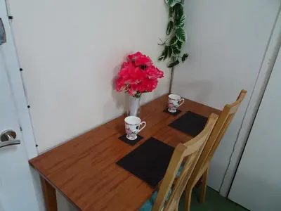 a wooden table with a vase of red flowers on it at CHARLES INN in Liverpool