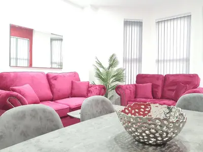 a living room with pink couches and a table at DYSA Banks Apartments in Blackpool