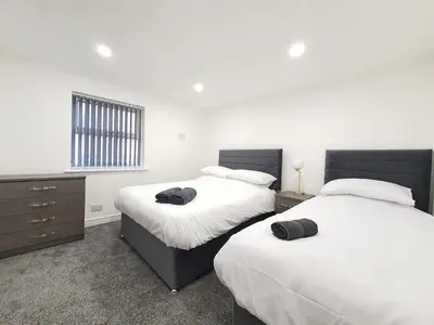 a bedroom with two beds and a window at DYSA Banks Apartments in Blackpool