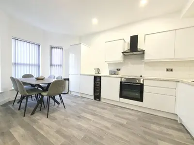 a kitchen with a table and chairs in a room at DYSA Banks Apartments in Blackpool