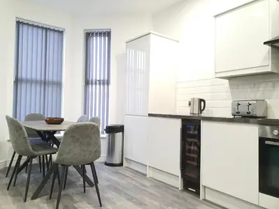 a kitchen with a table and chairs in a room at DYSA Banks Apartments in Blackpool