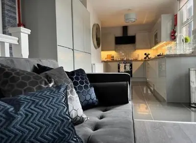 a living room with a couch and a kitchen at Room 4 (8 Holland Street) in Liverpool