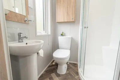 a bathroom with a toilet and a sink and a shower at Loluke Lodge on The Lake in Carnforth