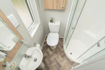 a small bathroom with a toilet and a shower at Loluke Lodge on The Lake in Carnforth