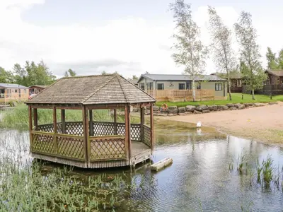 a gazebo in the middle of a pond at Loluke Lodge on The Lake in Carnforth