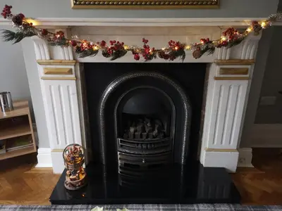 a fireplace with a christmas garland on top of it at 34 One in Lytham St Annes