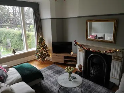 a living room with a christmas tree and a fireplace at 34 One in Lytham St Annes