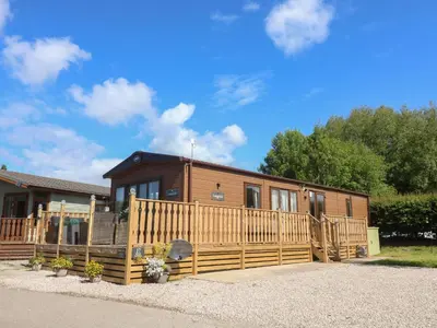 a house with a wooden fence in front of it at Langdale Lodge in Carnforth