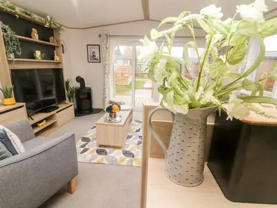 a living room with a vase with flowers in it at Langdale Lodge in Carnforth