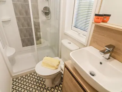 a bathroom with a toilet and a shower and a sink at Langdale Lodge in Carnforth