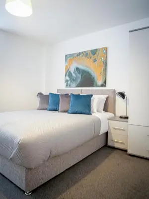 a bedroom with a large bed with blue pillows at Winkley House by Guestz in Preston