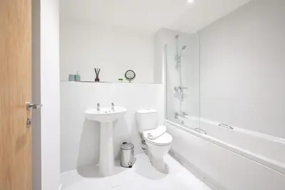 a white bathroom with a toilet and a sink at Winkley House by Guestz in Preston