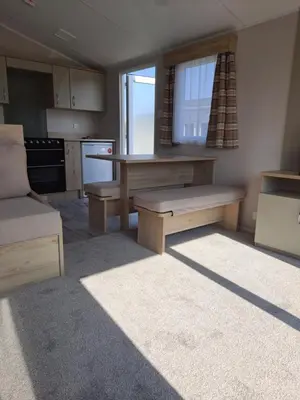 a kitchen with a bench and a table in it at Edwards Holiday Home in Blackpool