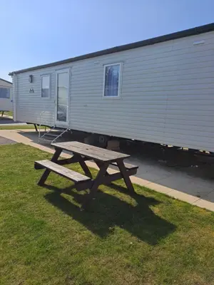 a wooden picnic table in front of a trailer at Edwards Holiday Home in Blackpool