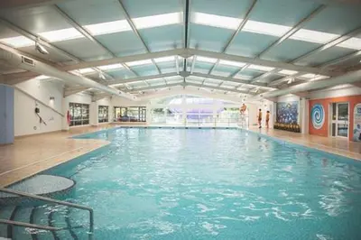 a swimming pool with blue water in a building at Edwards Holiday Home in Blackpool