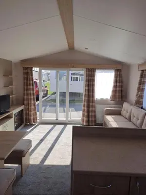 a living room with a couch and a large window at Edwards Holiday Home in Blackpool